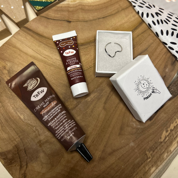 Coffret Eclat Hivernale en collaboration avec Pimah Création, ce coffret de Noël comprend : une crème mains nuit odeur Amande, un baume à lèvres nuit odeur Cacao et une bague en acier inoxydable